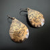 lotus flowers stamped in a pattern on an oxidized brass teardrop with hypoallergenic niobium ear wires